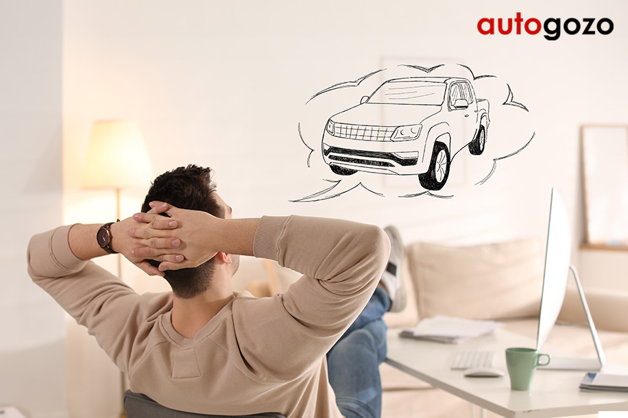 Hombre soñando con tener un carro sentado en un escritorio